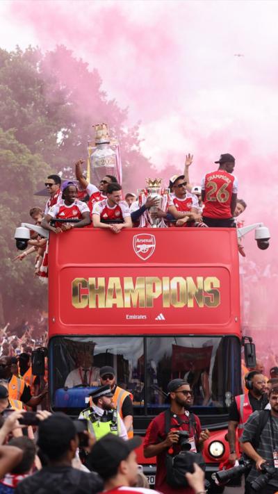 The Arsenal team in open-topped buses arrive at the Emirates Stadium during a victory parade 