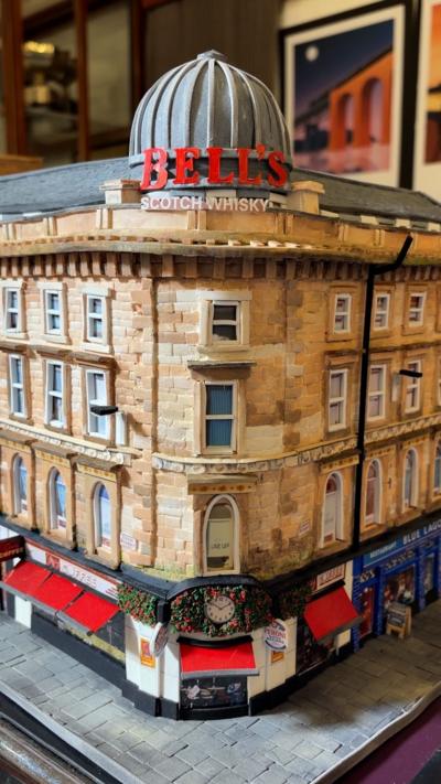 Miniature model of Union Corner in Glasgow, the sandstone building has a dome at the top and a cafe at ground level