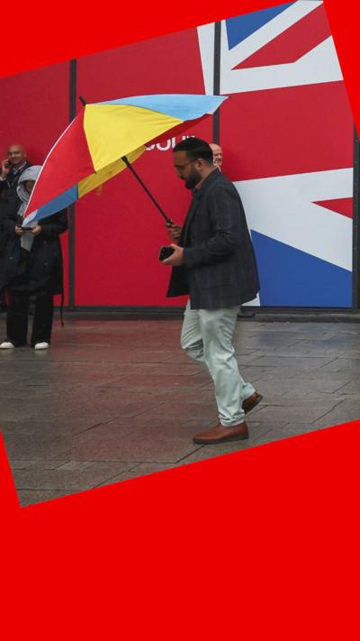 Man holding an umbrella outside the Labour Party conference in Liverpool