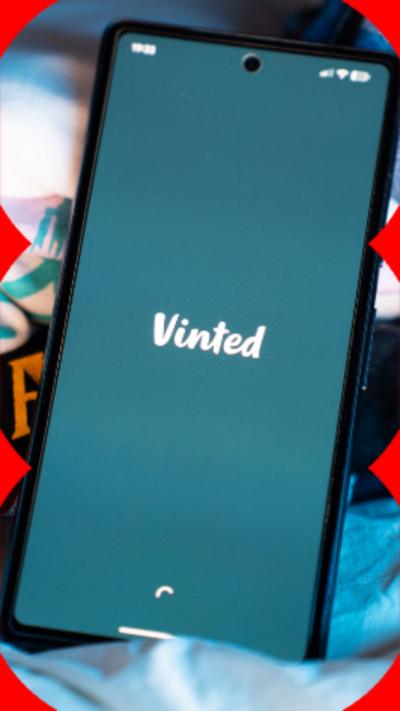 A mobile phone with its screen displaying the Vinted app logo.