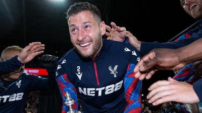 Joel Ward of Crystal Palace walks out on to the pitch holding the Emirates FA Cup