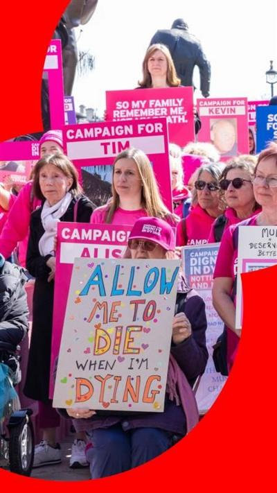 A group of people dressed in pink holding signs in support of assisted dying.