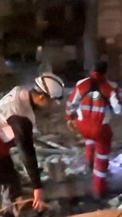 Rescue workers dig through rubble 