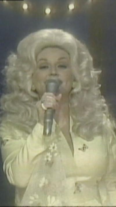 Dolly holding a microphone and singing