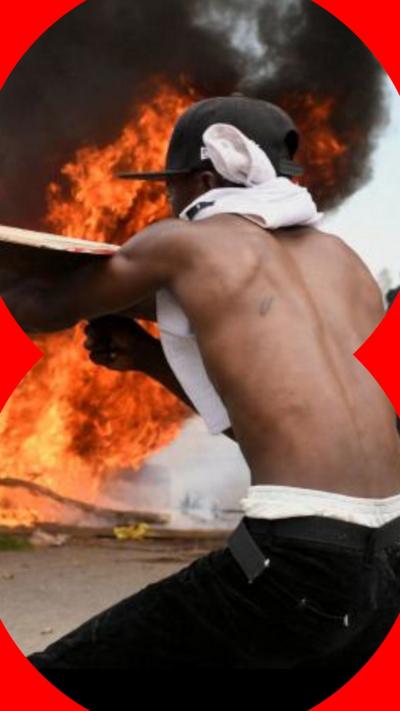 Demonstrator stands in front of burning tyre in Nanyuki, Kenya