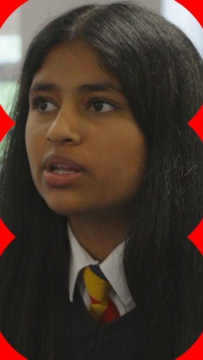 A girl with long, dark hair looks at someone off-camera