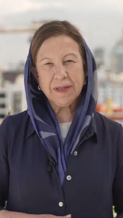 Lyse Doucet wearing a navy blue coat and headscarf