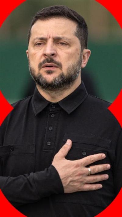 Volodymyr Zelensky dressed in all black with his right hand placed across his chest.