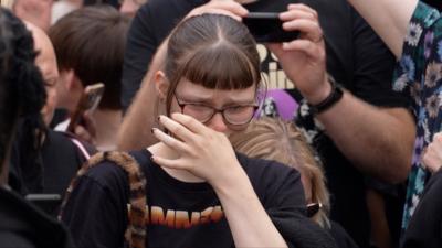 A fan cries during Ozzy Osbourne's funeral parade