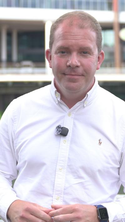 Huw Thomas in a white shirt with a clip mic on