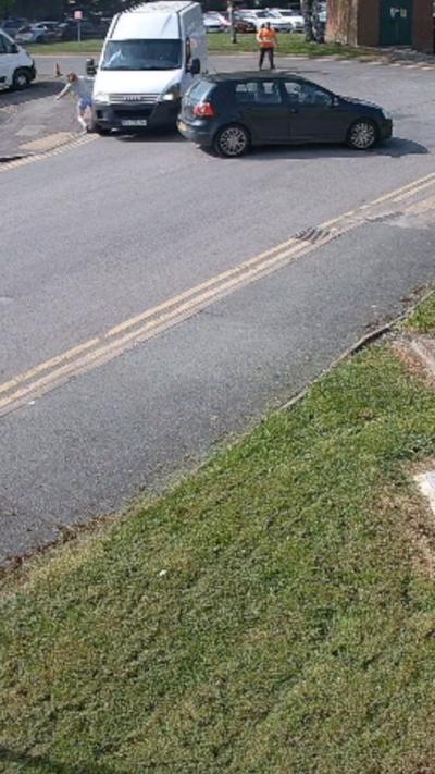 A woman knocked down by a white van in a street
