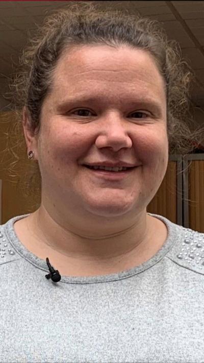 Emily Hayman mewn crys llwyd yn gwenu