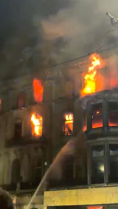Large flames erupting from upper windows of a building on Princes Street