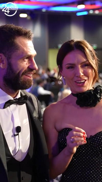 A man and a woman speak to the camera