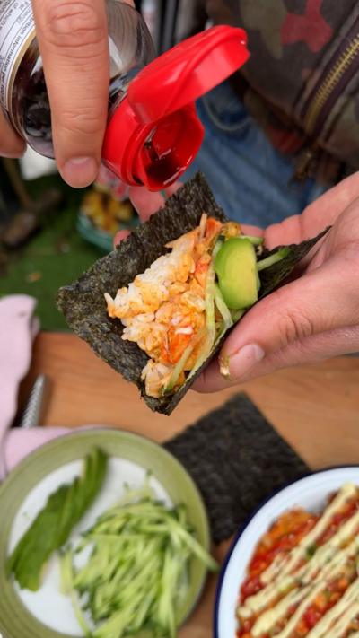 Pouring soy sauce onto a salmon sushi taco.