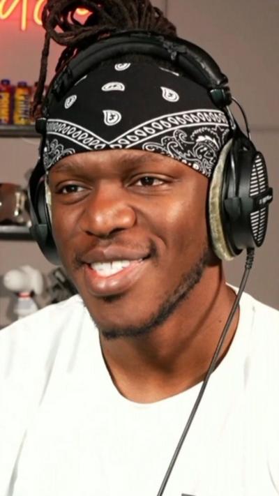 Man with a bandana and headphones on in a white t shirt.