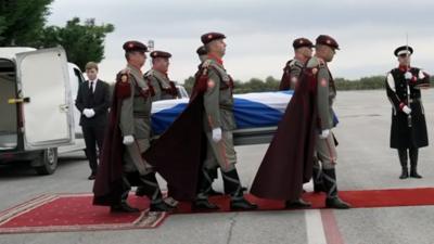 North Macedonian soldiers carrying Alex Salmond's coffin draped in a Saltire towards a private jet