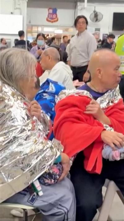 People are seen wrapped in foil and blankets, surrounded by first responders.