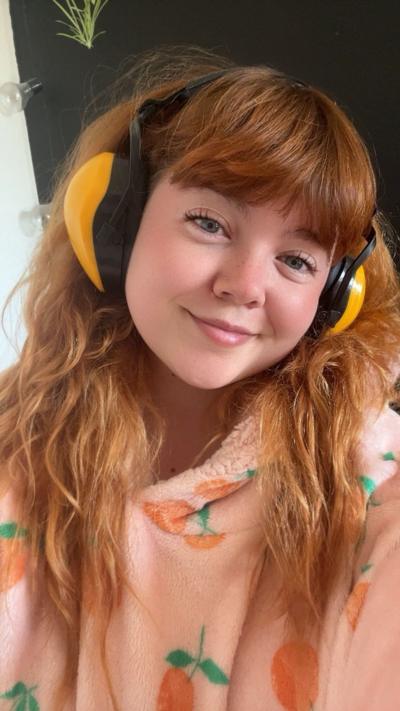Celyn Harvey wearing yellow ear defenders and smiling into the camera