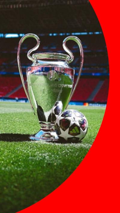 The Champions League trophy, with a football next it, inside a stadium pitch.