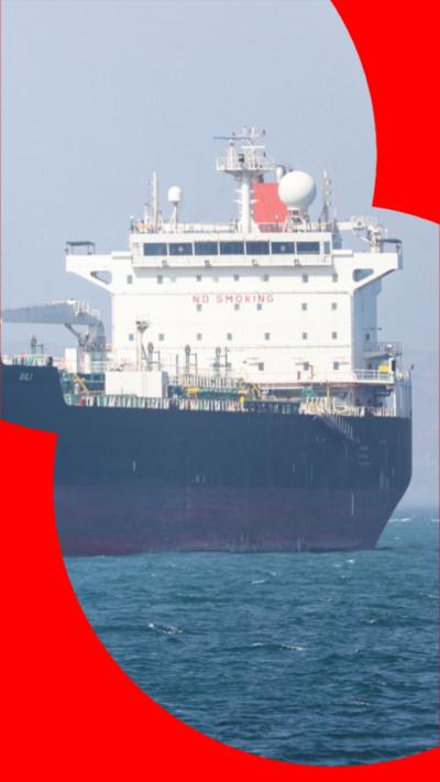 A large white, black and red cargo ship on a body of water