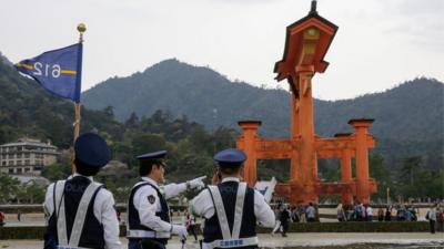 Japanese policemen check security near a wooden gate in Hatsukaichi, Hiroshima