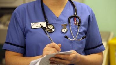 Hospital nurse writing up medical notes