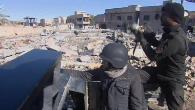 Thomas Fessy with Iraqi soldier driving through Ramadi looking at rubble