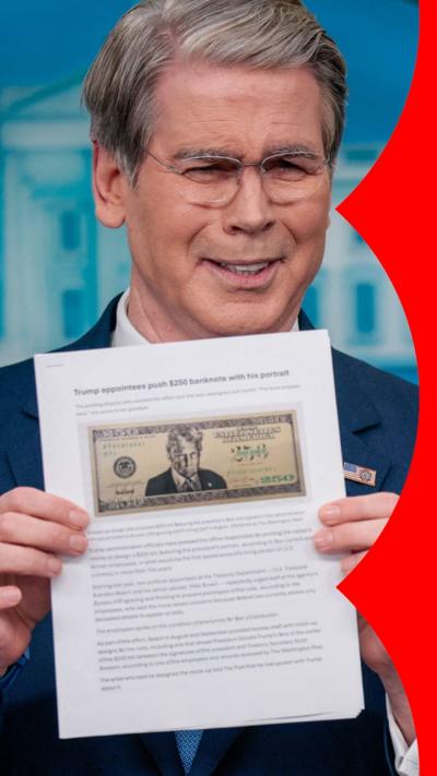 A man with short, grey hair holds up a piece of paper with a note on it