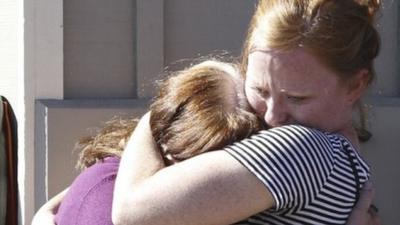 Umpqua Community College alumnus Donice Smith (L) is embraced after she said one of her former teachers was shot dead.