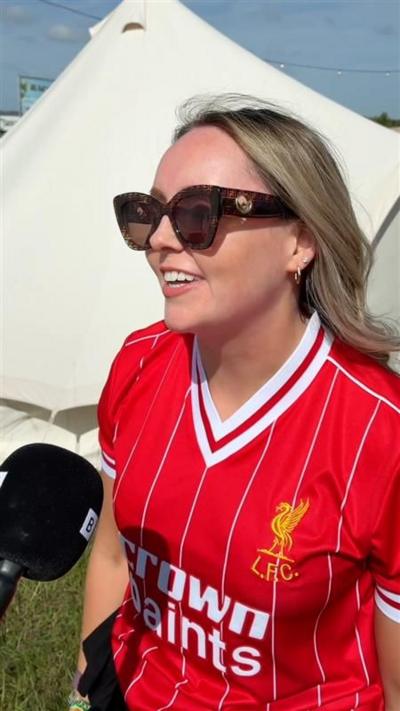 A blonde woman in a Liverpool Football Club shirt