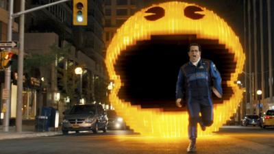 A scene from Pixels - a man is being chased by Pac Man