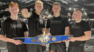 Adam, James, Dan and Nathan Braniff pose with a belt