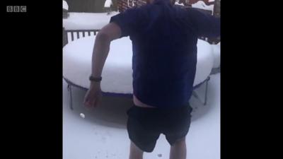 Man jumps on trampoline in the snow