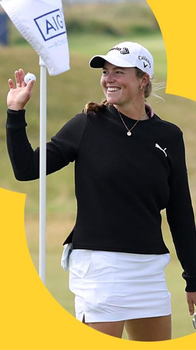 Golfer Mimi Rhodes smiles and holds up a ball in her right hand