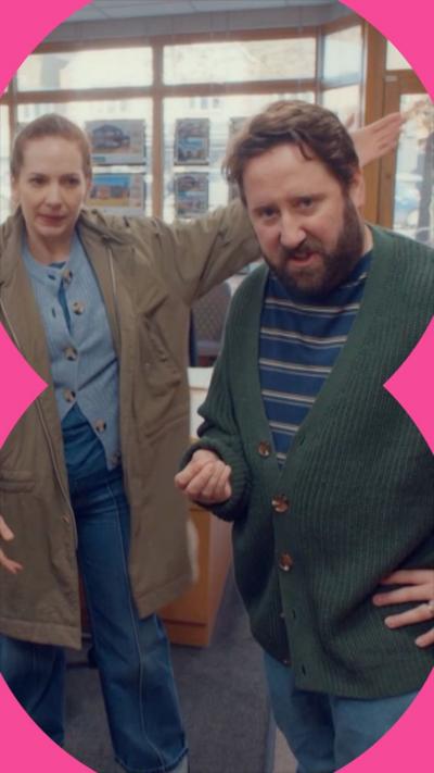 Characters Rachel and Paul Jessop standing in an estate agency, looking concerned 