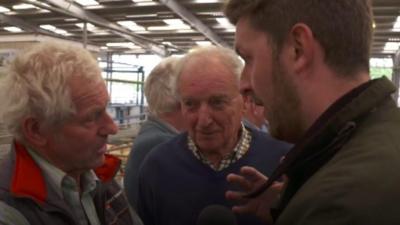 Two farmers chat to a reporter