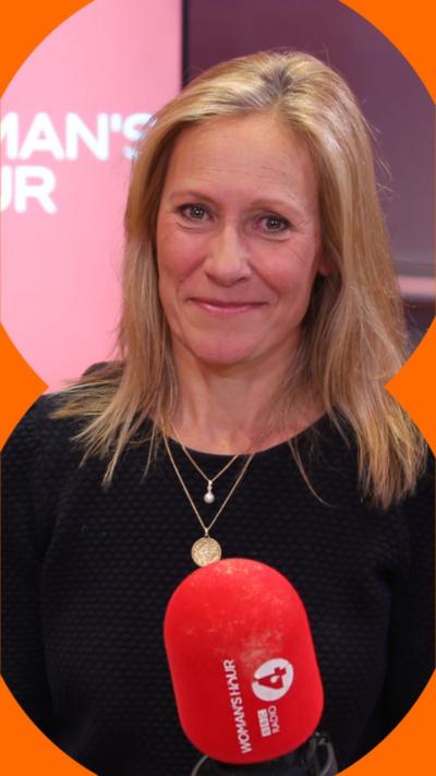 Sophie Raworth smiling, sat in a chair in a radio studio with a red mic in front of her.