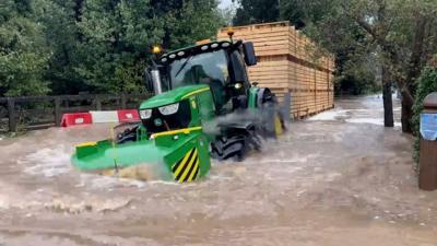 A tractor driving through Rufford Lane ford