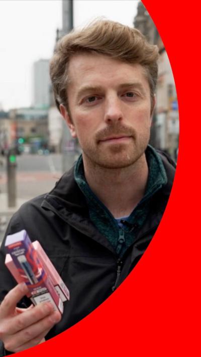 A man holds disposable vape boxes in his hand