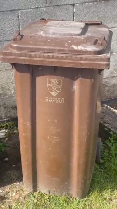 A brown recyling bin