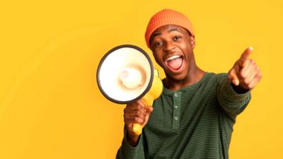 Man pointing with one hand, a megaphone in the other 