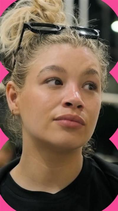 Molly looks unimpressed - she has blonde hair tied up and glasses on top of her head