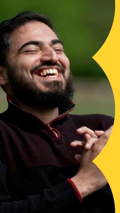 Contestant Raees laughs while holding his hands together 