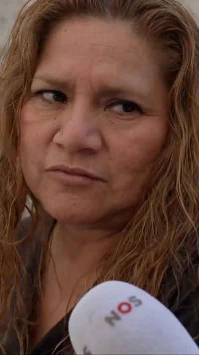 A woman speaks to a journalist 