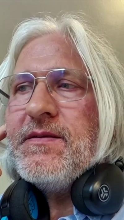 Christian Ege has long white hair and headphones around his neck