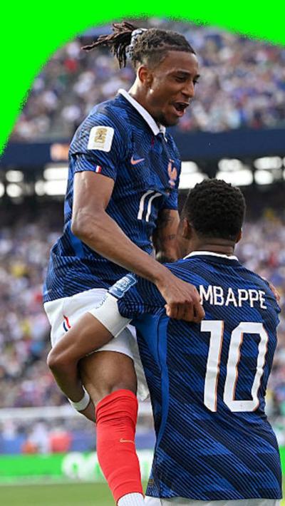 Michael Olise jumping in to the arms of  Kylian Mbappé