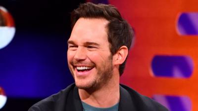 Chris Pratt smiling on the sofa of the Graham Norton set