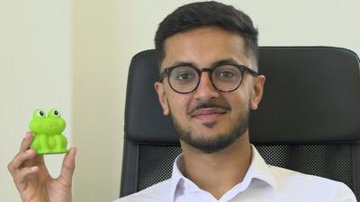 Akshay Ruparelia holds a plastic toy frog in his hand