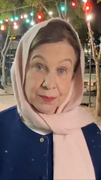 Lyse wears a navy jacket, pink headscarf as she looks into the camera